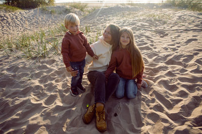 Photographer shoots family in autumn on the sand by the sea