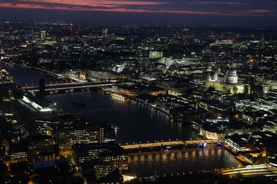 High angle view of illuminated city by river at night