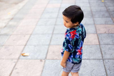 High angle view of girl standing on footpath