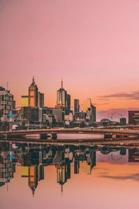 Reflection of buildings in lake during sunset