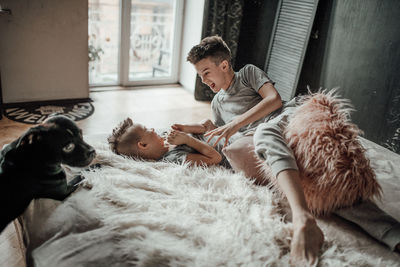 Kids playing while sitting on sofa at home