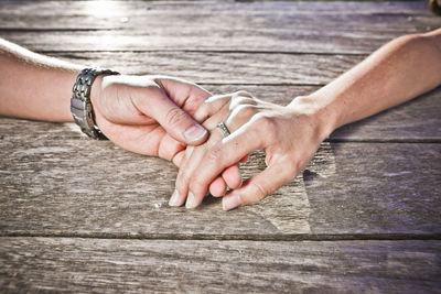 Cropped image of couple holding hands at table