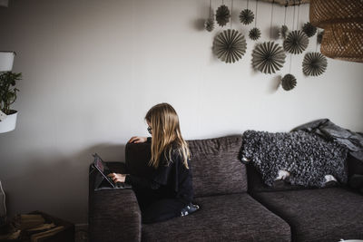 Woman sitting on sofa at home