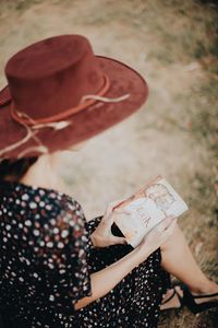 Rear view of woman wearing hat sitting outdoors