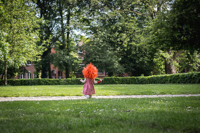 Rear view of woman walking on field