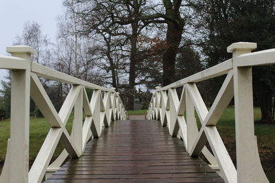 Bridge by trees against sky