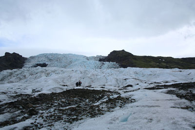 Scenic view of snow covered land against sky