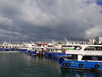 Boats moored at harbor against sky