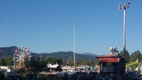 People in amusement park against clear sky