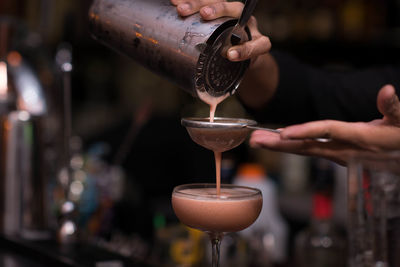 Close-up of bartender pouring cocktail