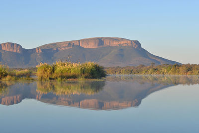 Scenic view of lake by mountain against sky