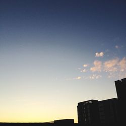 Low angle view of buildings against sky at sunset