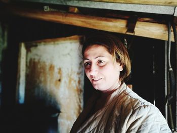 Thoughtful mature woman looking away while standing at doorway