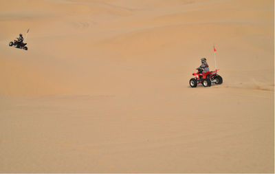 People riding quadbikes on desert