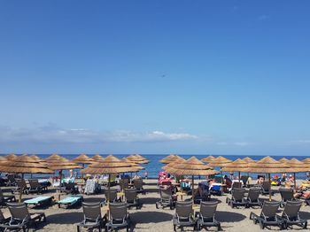 Scenic view of beach umbrellas against blue sky