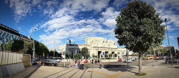 Buildings in city against cloudy sky
