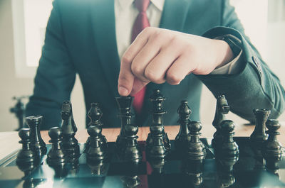 Midsection of businessman playing chess
