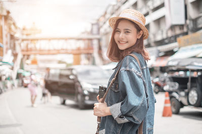 Portrait of woman standing on street in city