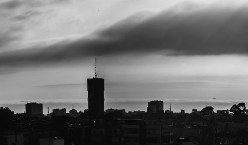 Buildings in city against cloudy sky