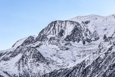 Scenic view of snowcapped mountains against clear blue sky