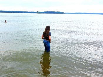 Woman standing on beach against sky