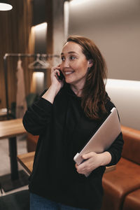 Adult confident business woman freelancer working in a coffee shop cafe using a laptop and phone