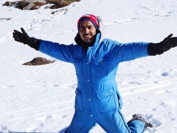 Full length of smiling young woman in snow