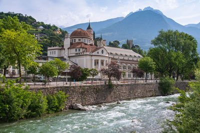 Houses by river against sky