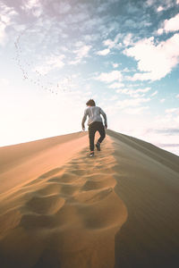 Rear view of man on sand dune