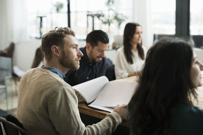 Business people listening during meeting at table in office