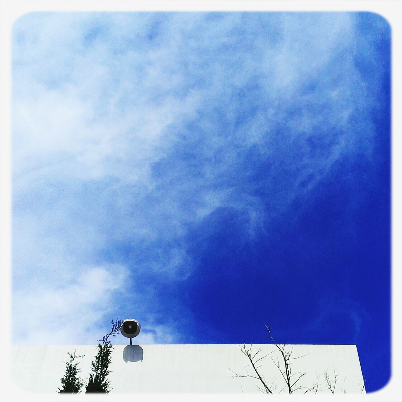 low angle view, transfer print, sky, auto post production filter, blue, cloud - sky, street light, cloudy, lighting equipment, cloud, built structure, high section, outdoors, day, no people, nature, building exterior, architecture, electricity, communication