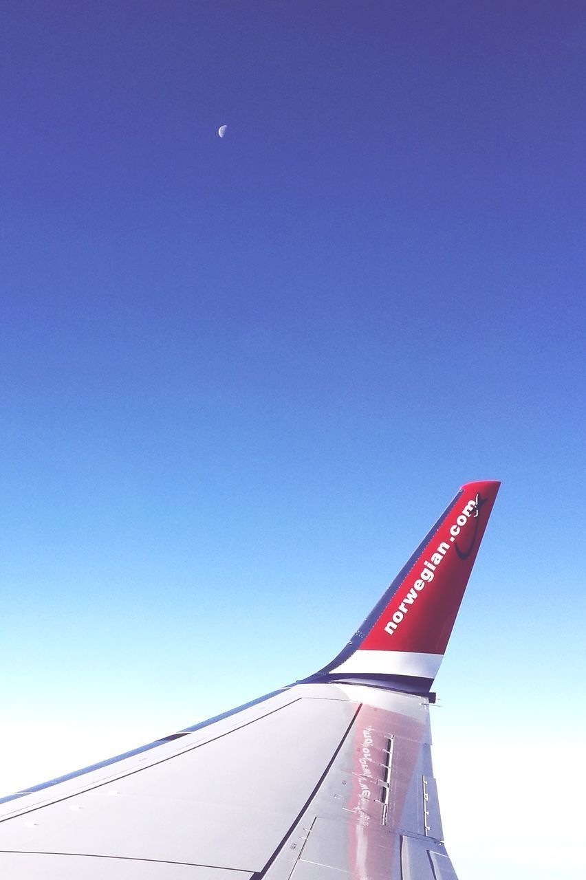 CLOSE-UP OF AIRPLANE WING AGAINST BLUE SKY