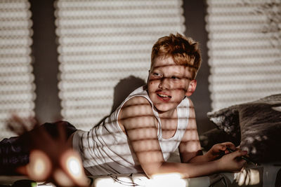 Portrait of boy sitting on sofa at home