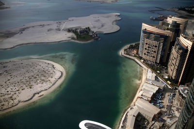 High angle view of cityscape by sea against sky