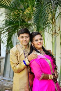 Portrait of smiling young couple standing outdoors