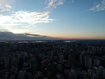 Aerial view of buildings in city against sky during sunset