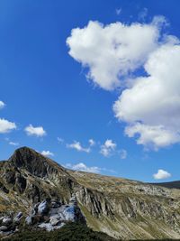 Low angle view of mountain against blue sky