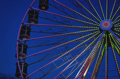 Low angle view of ferris wheel against clear blue sky