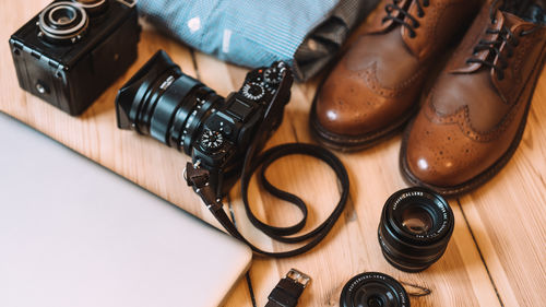 Shoes with laptop and camera on table