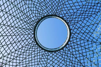 Directly below shot of clear blue sky seen through patterned ceiling