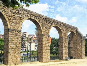 Arch bridge over old building against sky