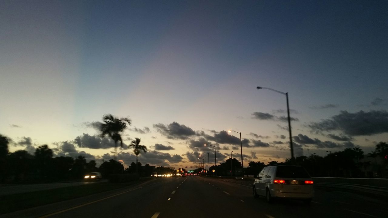 transportation, car, land vehicle, road, mode of transport, road marking, on the move, street, sky, the way forward, traffic, highway, travel, street light, diminishing perspective, motion, illuminated, vanishing point, outdoors, vehicle