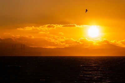 Scenic view of sea against orange sky