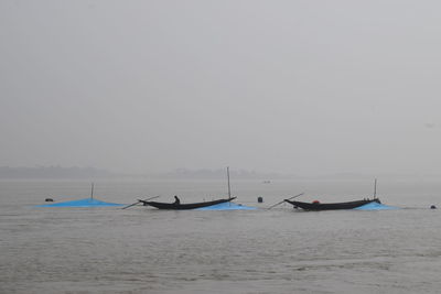 View of boats in sea against clear sky