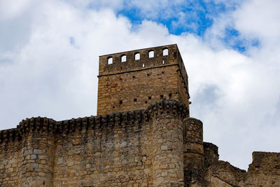 Low angle view of old building against cloudy sky