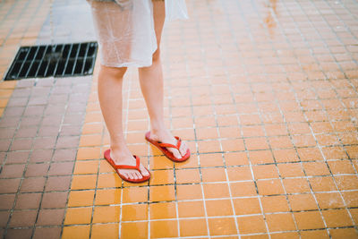 Low section of woman standing on footpath