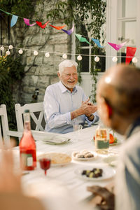 Happy senior men sitting at dining table in back yard