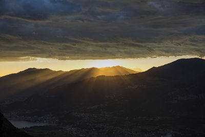 Storm clouds over silhouette mountains during sunset