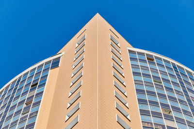 Low angle view of modern building against clear blue sky