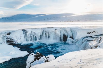 Scenic view of waterfall against sky during winter